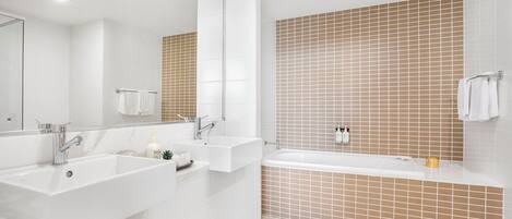 Ein modernes Badezimmer mit zwei Waschbecken, einer Badewanne und einer Dusche.