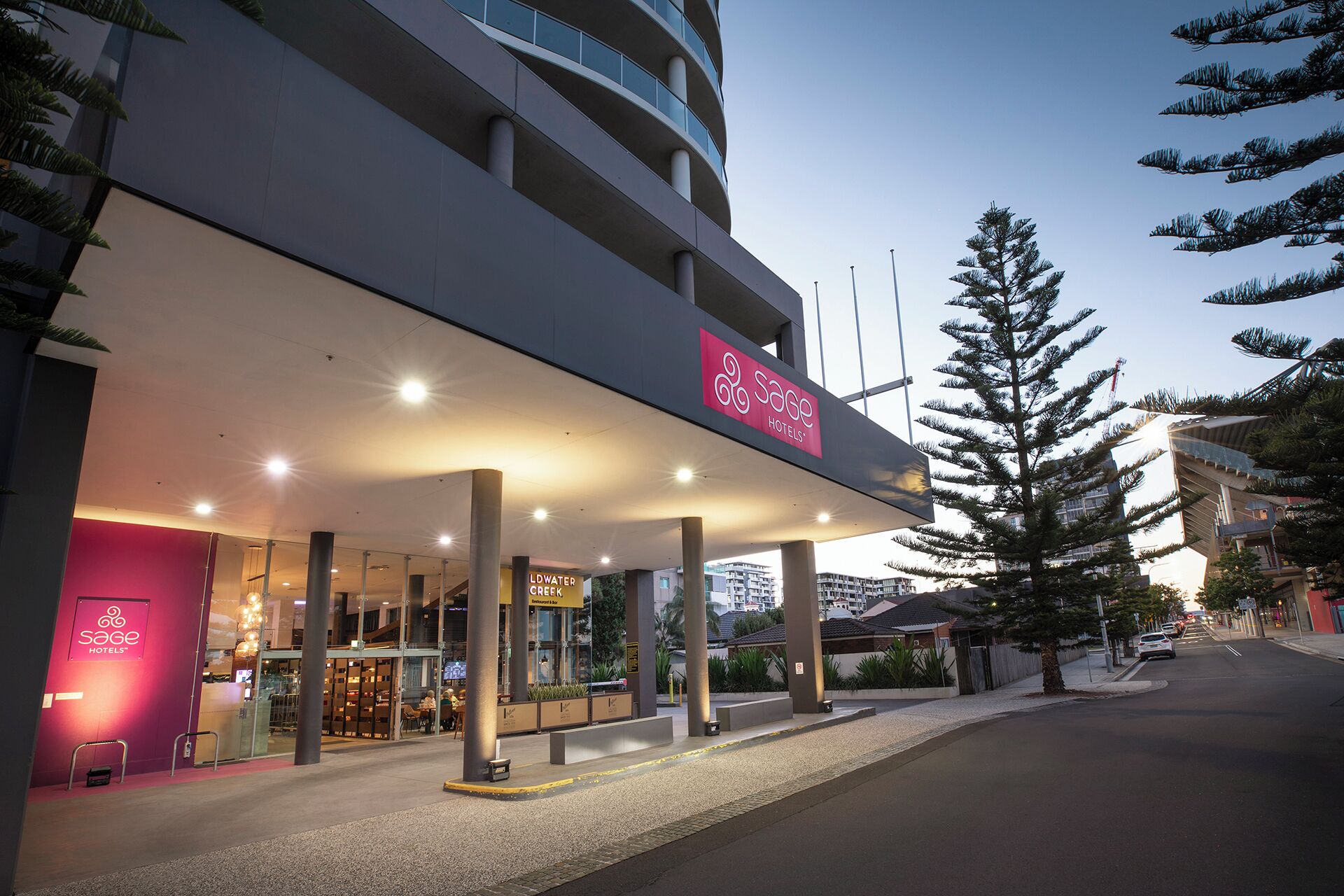 A hotel with a modern design, featuring a prominent sign for Sage Hotels.