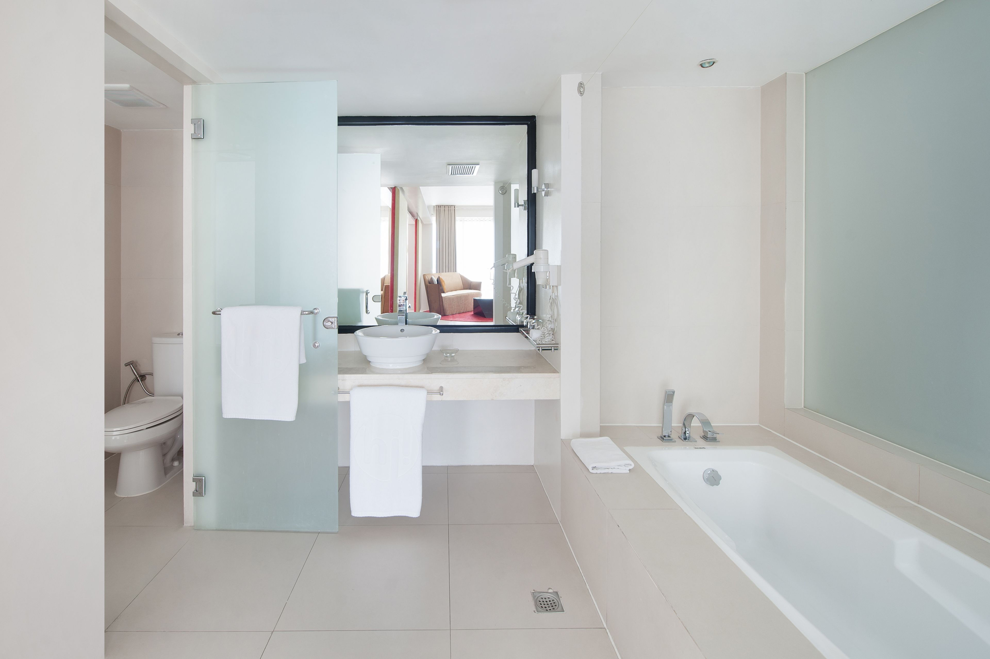 A modern bathroom with a bathtub, a sink, and a toilet.