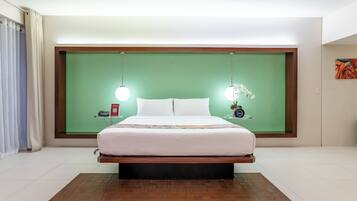 Een moderne hotelkamer met een groot bed, een groene accentmuur, nachtkastjes met lampen en een schilderij aan de muur.