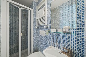 A bathroom with a shower, a sink, and a mirror.