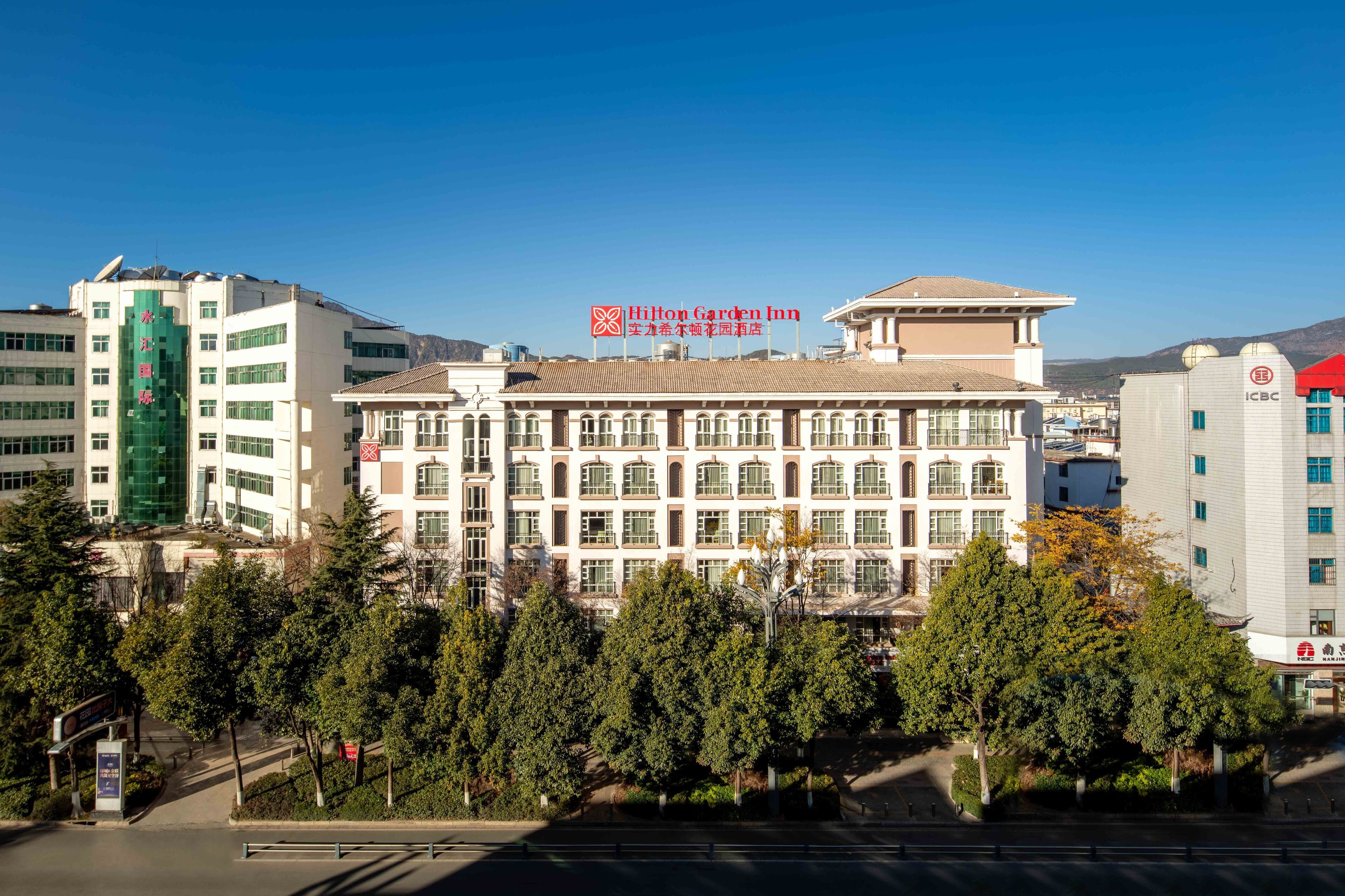 A multi-story hotel with a traditional architectural style, featuring a central courtyard and multiple windows.