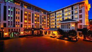 A hotel with multiple floors, a central courtyard, and a well-lit entrance. - Hilton Garden Inn Lijiang (Lijiang)