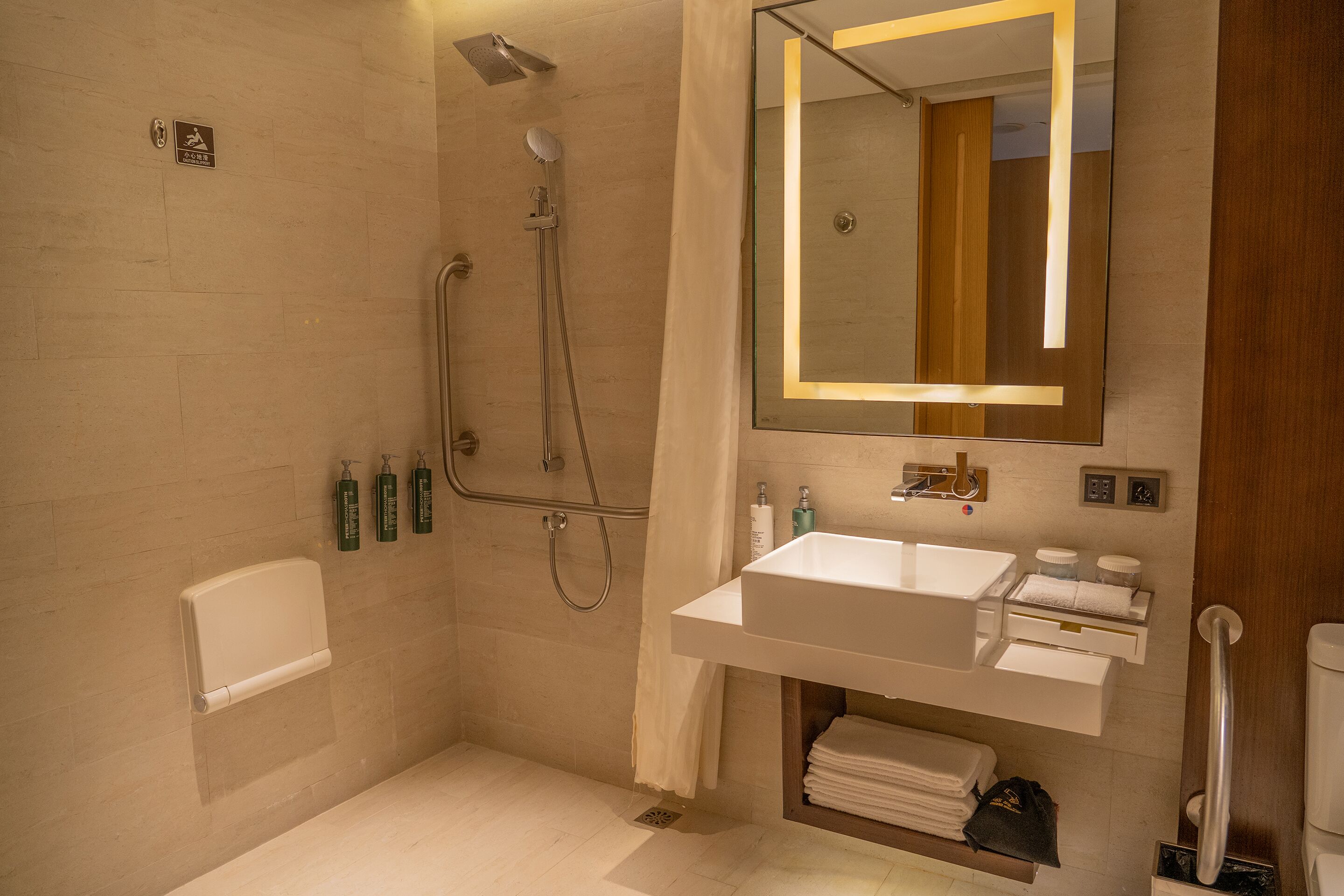 A modern bathroom with a shower, a sink, and a mirror.