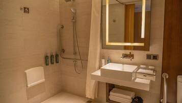 A modern bathroom with a shower, a sink, and a mirror.