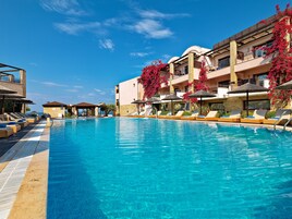 Una piscina al aire libre de temporada, sombrillas