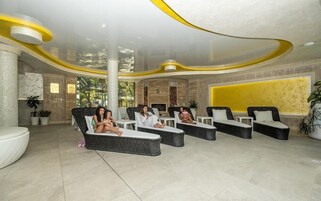 Un área de estar moderna con sillones reclinables, un pilar grande y una pared de acento amarilla.