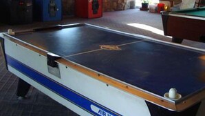 An indoor pool table with a sign reading "AIR HOCKEY" and arcade machines in the background. - Travel Inn Abilene (Abilene)
