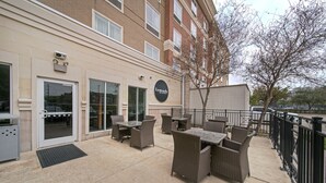 Un espace extérieur aménagé en terrasse, avec des meubles en osier et une enseigne indiquant « Legends Suites ».