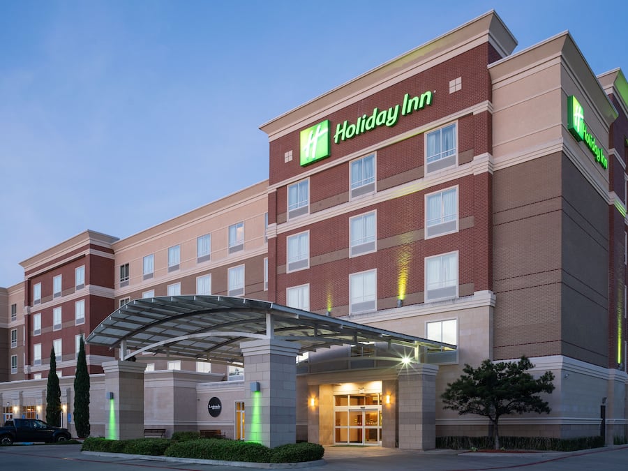 A Holiday Inn hotel with a covered entrance, multiple floors, and a brick facade.