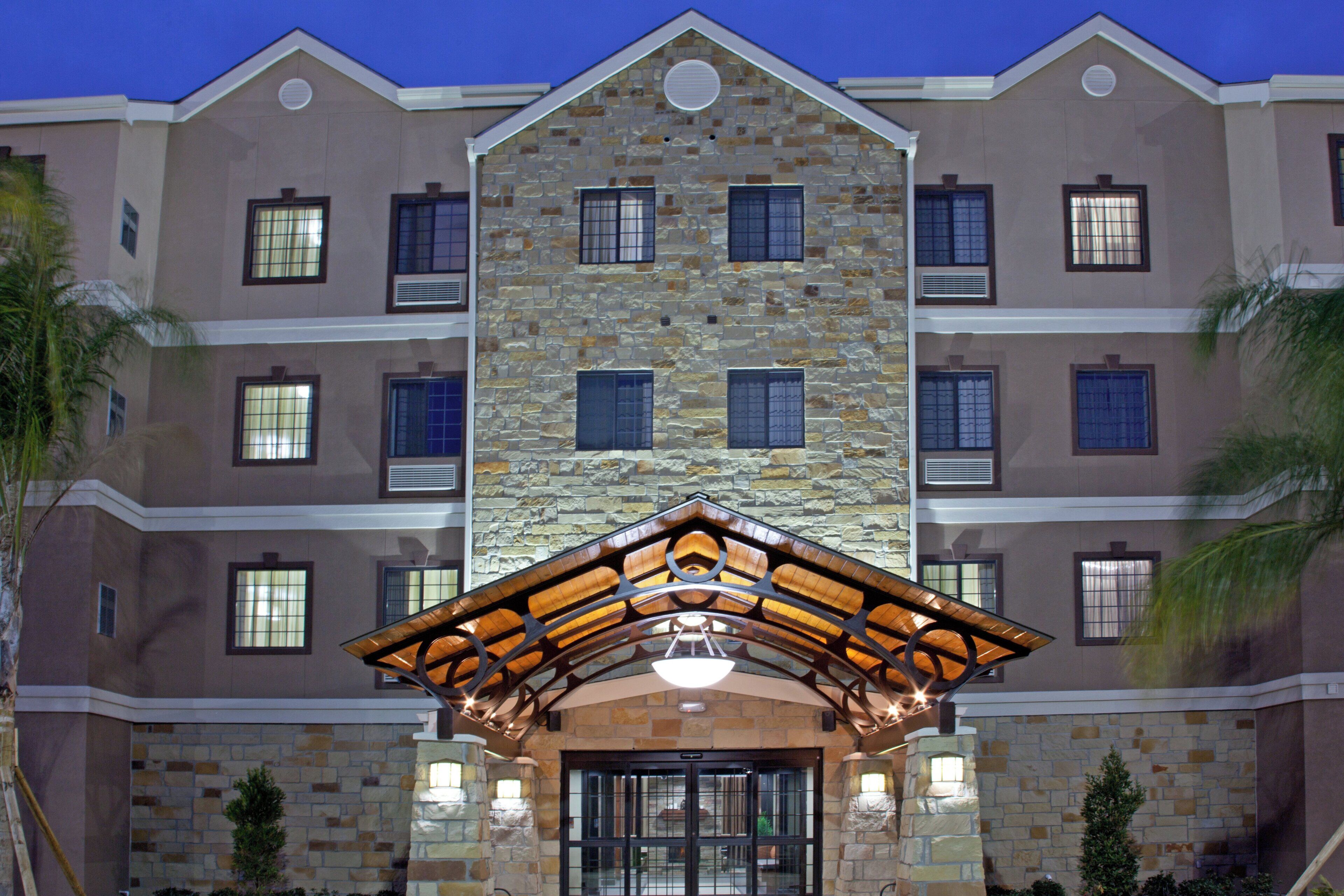A multi-story hotel with a stone facade, multiple windows, and a central entrance with a wooden canopy.