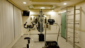 A gym with exercise equipment, a TV, and a mirror. - Lider Hotel Manaus (Manaus)