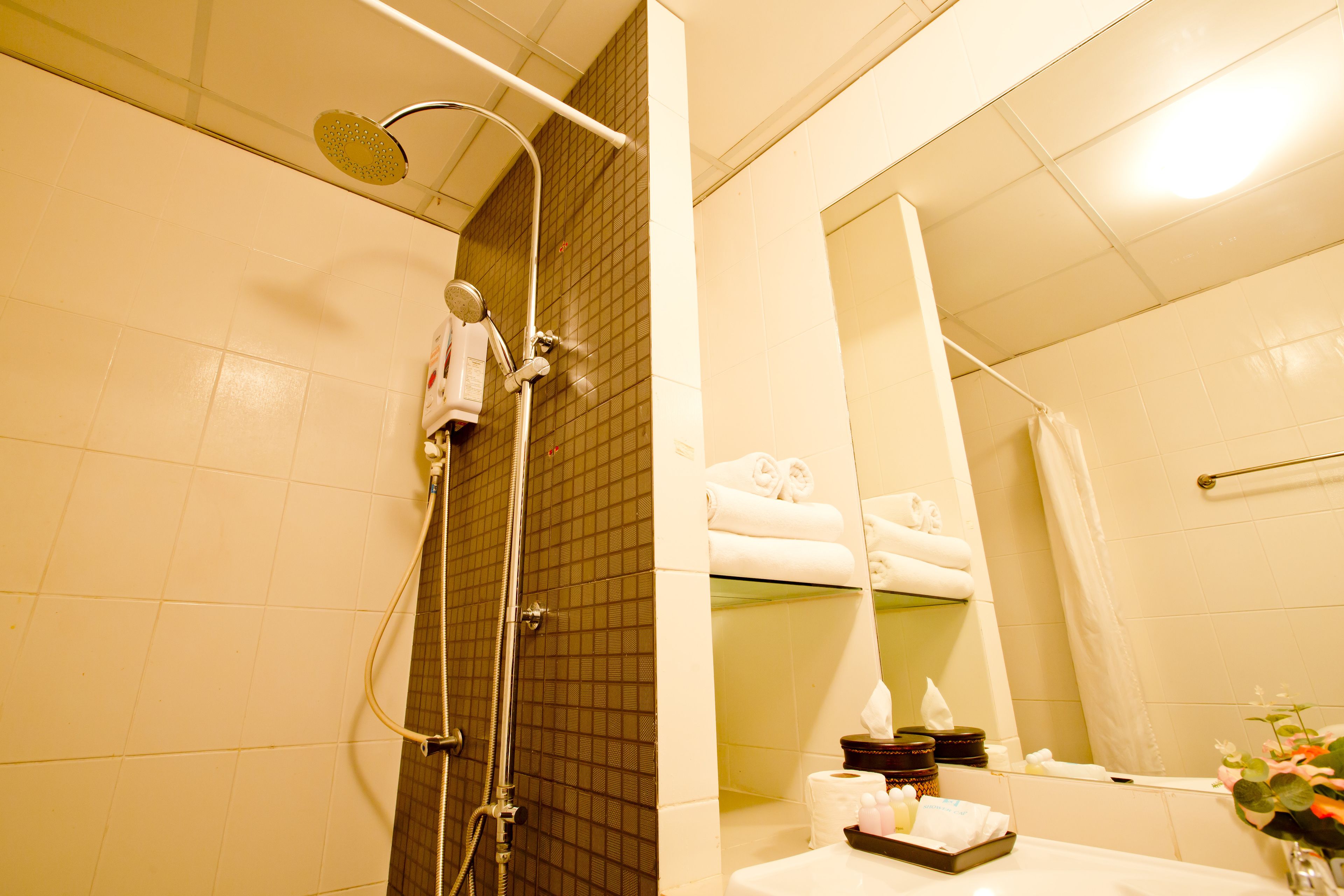 A bathroom with a shower, a sink, and a mirror.