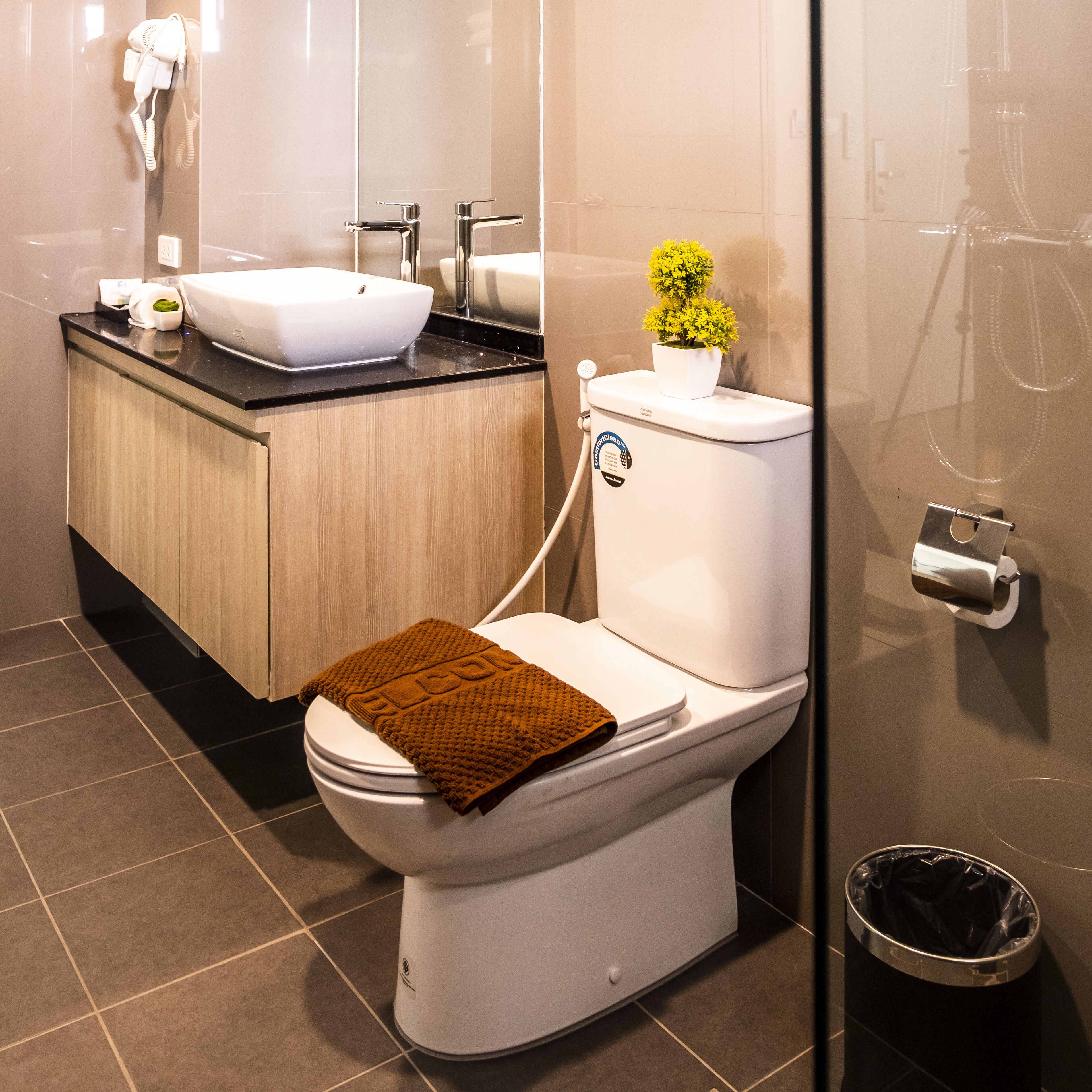 A modern bathroom with a toilet, sink, and shower.