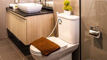 Un baño moderno con inodoro, lavabo y ducha.