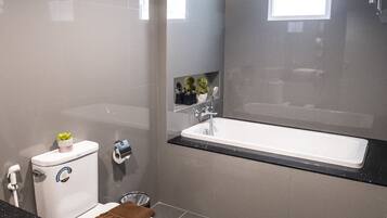 A modern bathroom with a toilet, sink, and bathtub.
