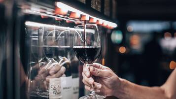 Une personne tenant un verre à vin devant une bouteille de vin.