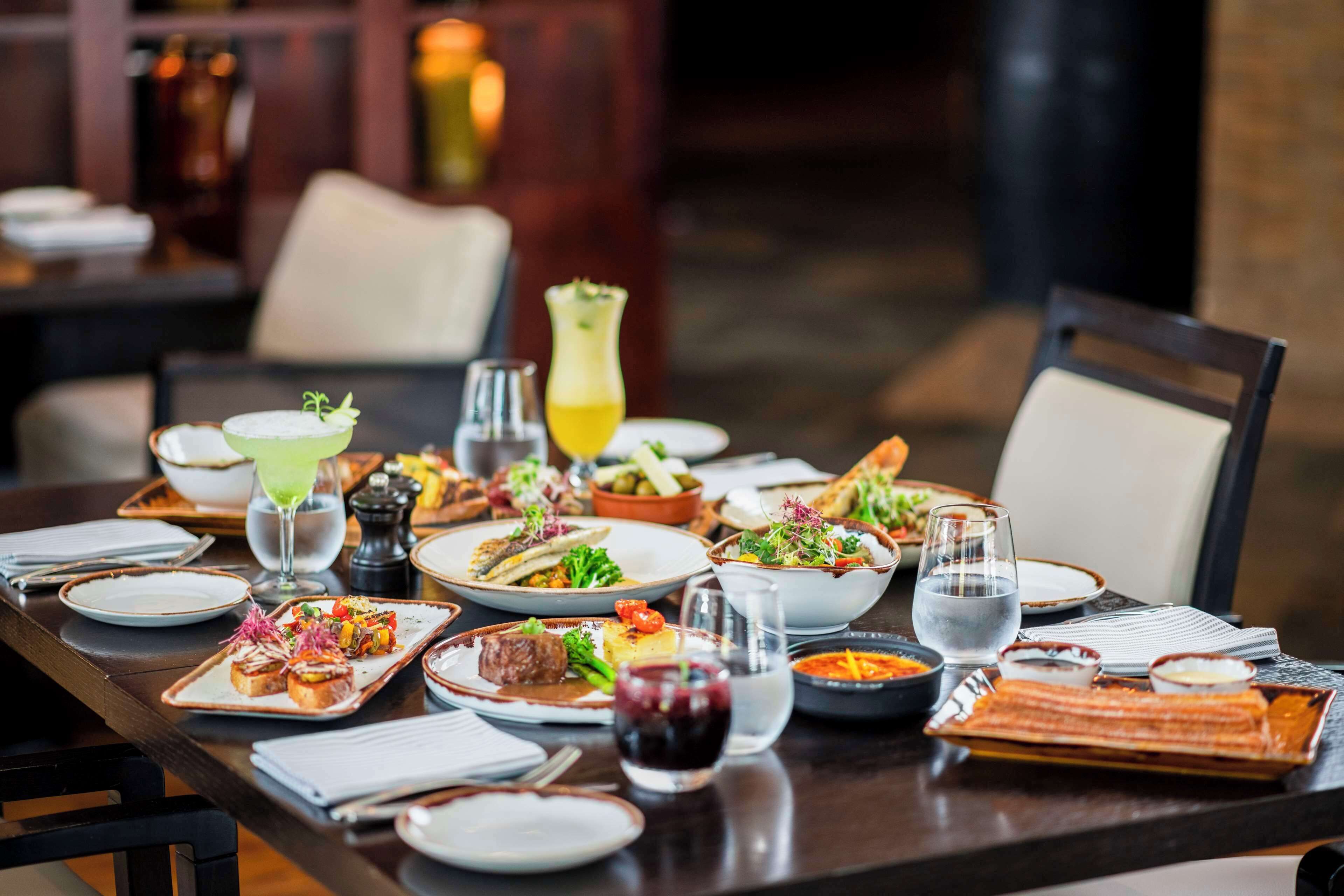 A well-set dining table with various dishes, glasses, and cutlery.