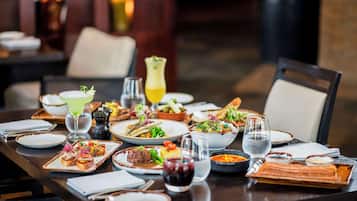 Una mesa de comedor bien dispuesta con diferentes platos, vasos y cubiertos.