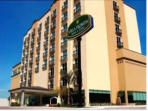 Un hotel de varios pisos con un letrero que dice "Villa Florida Hotel & Suites".