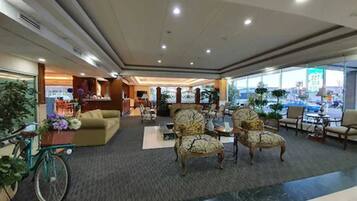 A spacious lobby with a seating area, a reception desk, and a bicycle.