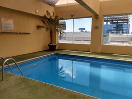 Una piscina techada, sillones reclinables de piscina