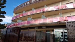Ein Hotel mit Spa-Bereich, das ein mehrgeschossiges Gebäude mit Balkonen und einem überdachten Eingang zeigt.