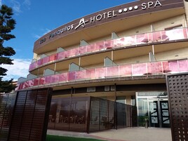 A hotel with a spa, featuring a multi-story structure with balconies and a covered entrance.