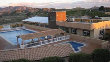 Een seizoensgebonden buitenzwembad en een zwembad met een waterval