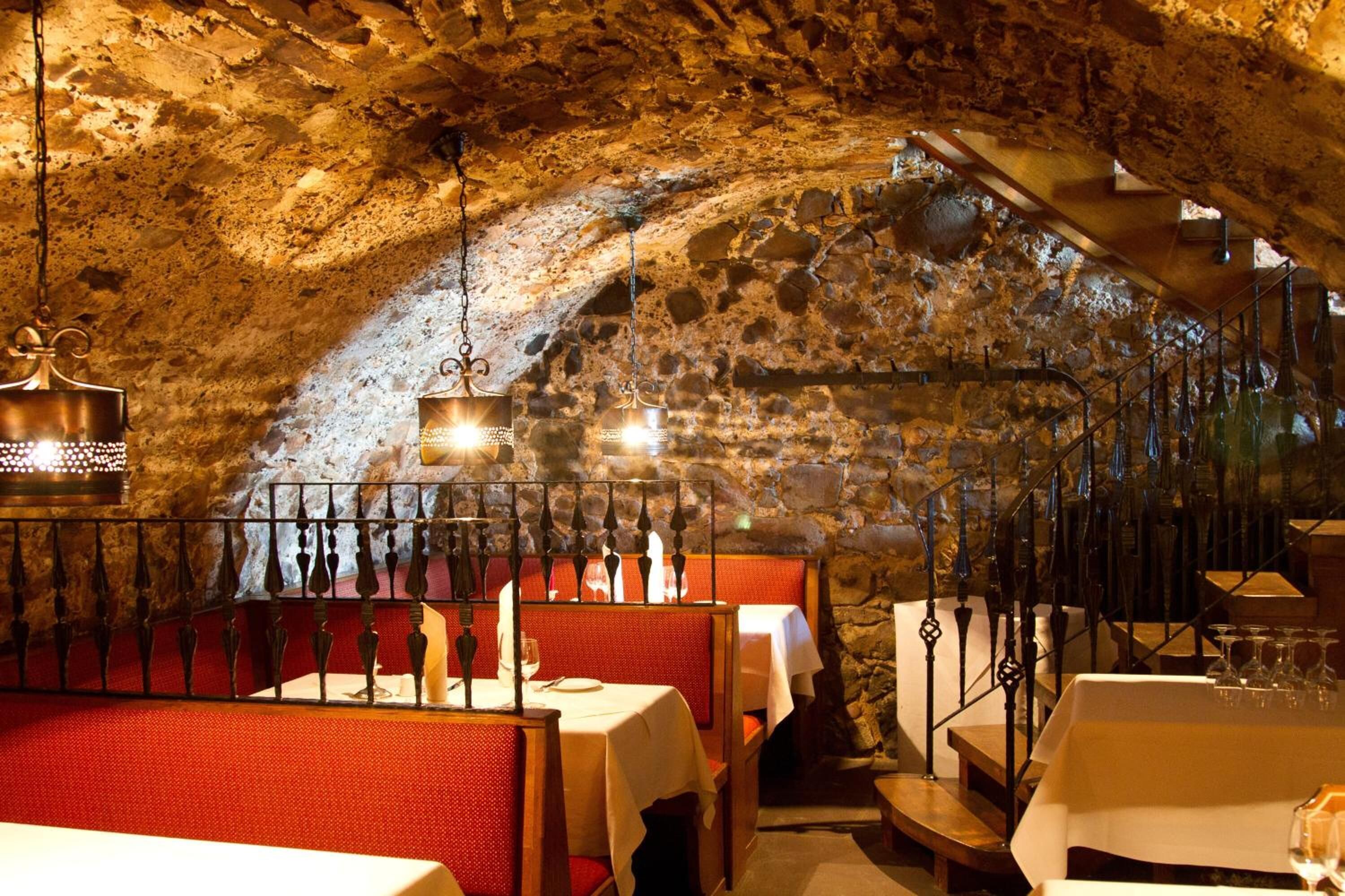 Ein Restaurant mit Stehwänden und Holztischen, das einen rustikalen Innenraum aufweist.