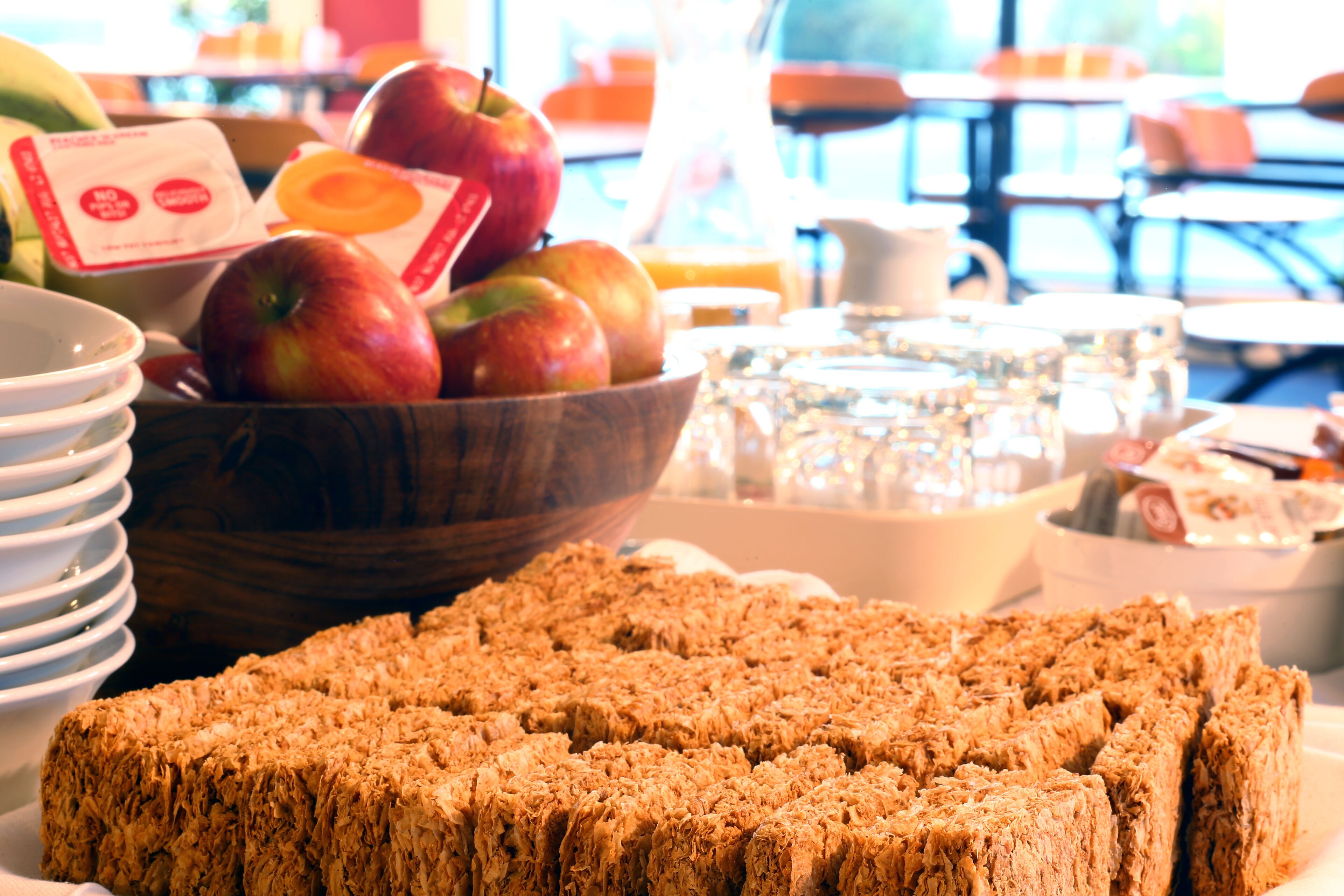 A breakfast buffet with a variety of fruits, including apples and bananas, and a selection of cereals.