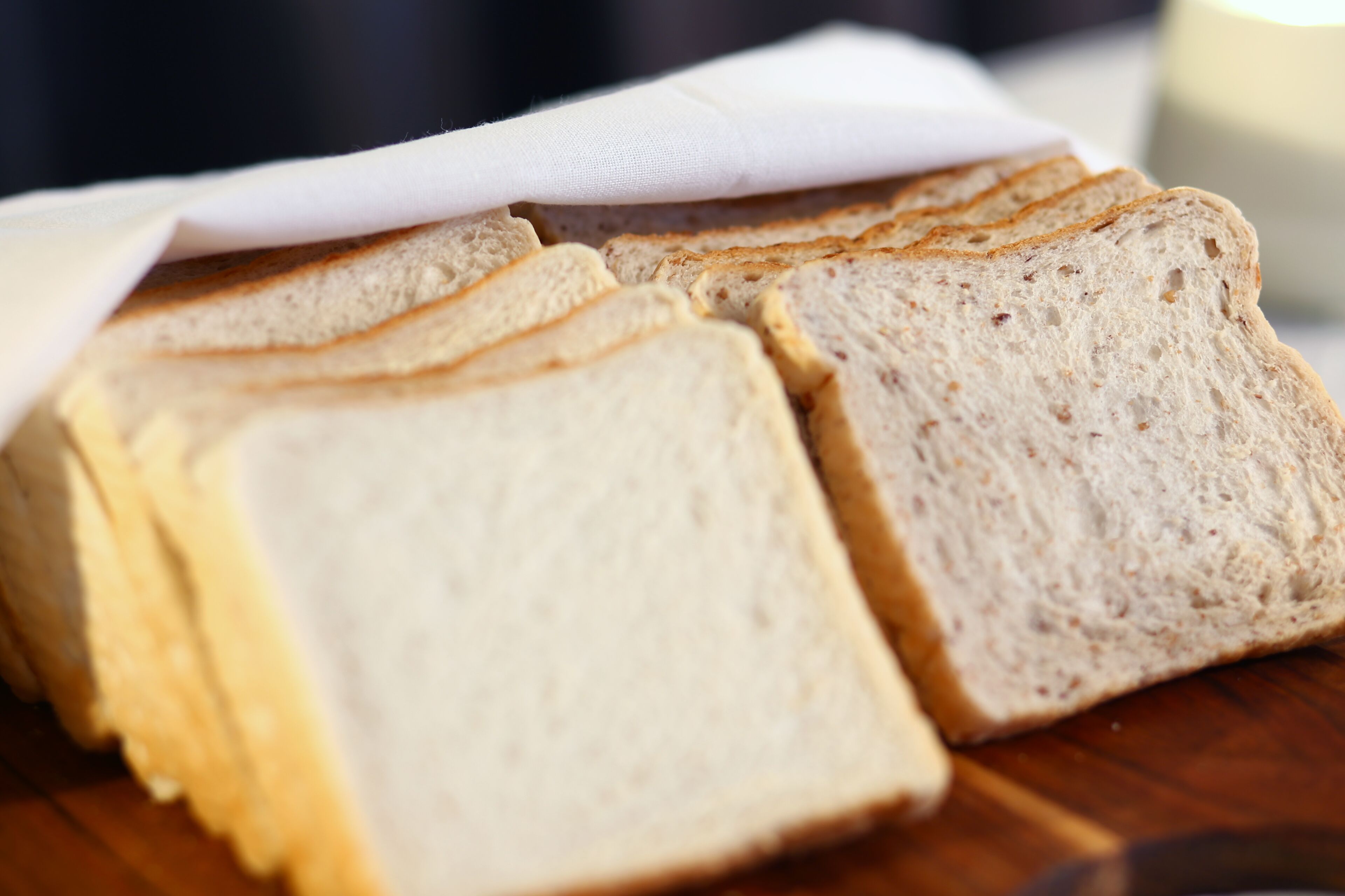 Slices of white bread on a wooden surface.