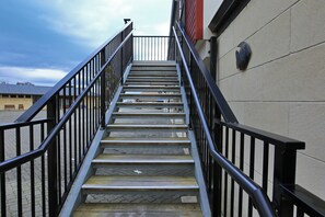 A set of outdoor metal stairs with a handrail, leading up to a building entrance. - Heritage Court Lodge  (Oamaru)