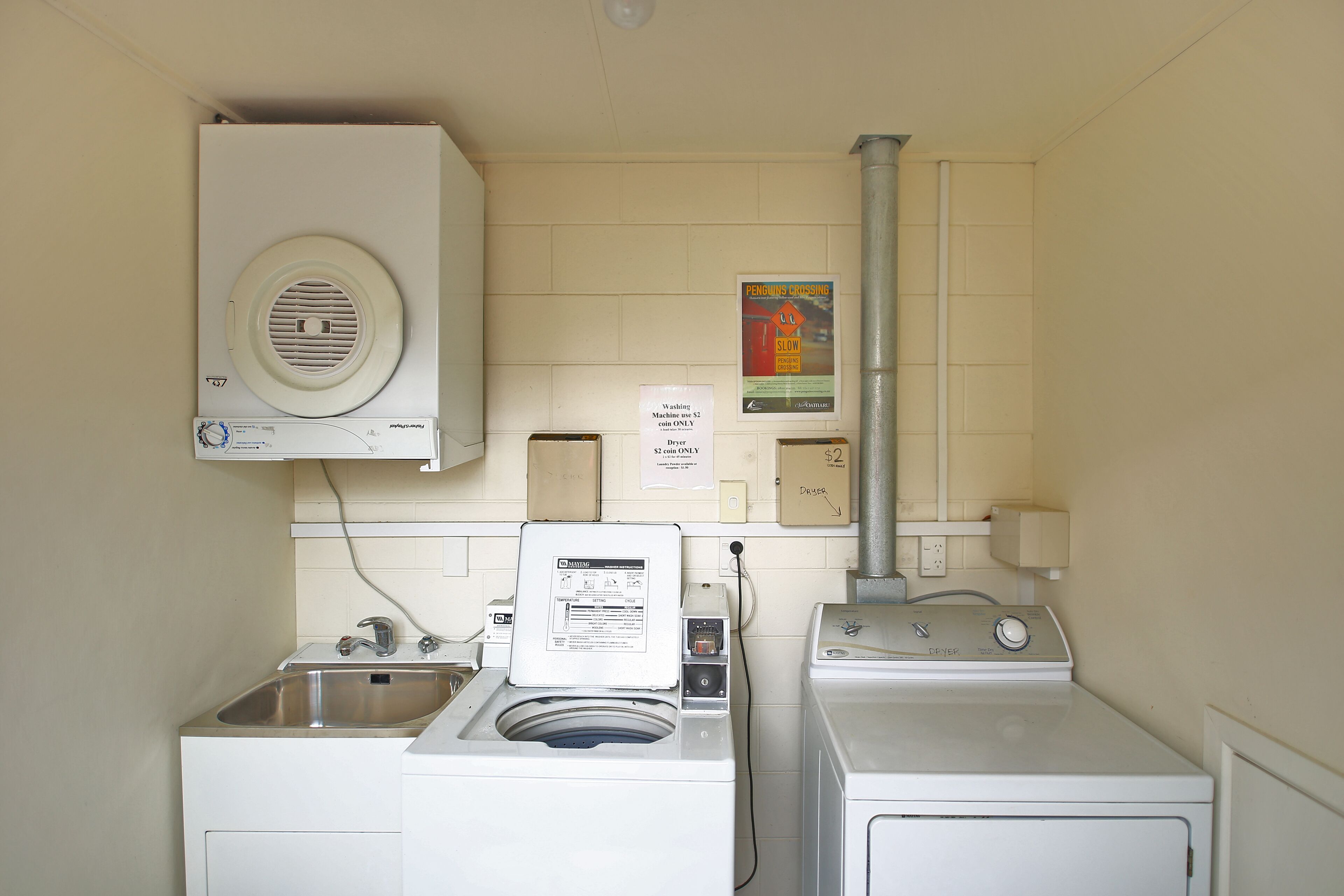 A laundry area with a washing machine, dryer, and a sink.