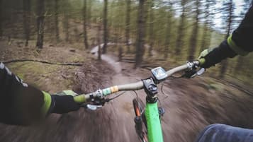 Une personne fait du vélo tout-terrain sur un sentier forestier.