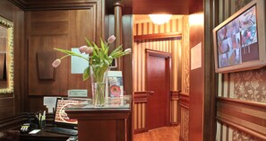 A reception desk with a vase of tulips, a computer, and a telephone. - Vila Terazije (Belgrade)
