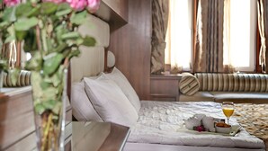 Habitación de hotel con cama, mesita de noche y un jarrón de flores.