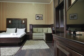 A hotel room with a large bed, a sofa, a TV, and a desk. - Vila Terazije (Belgrade)