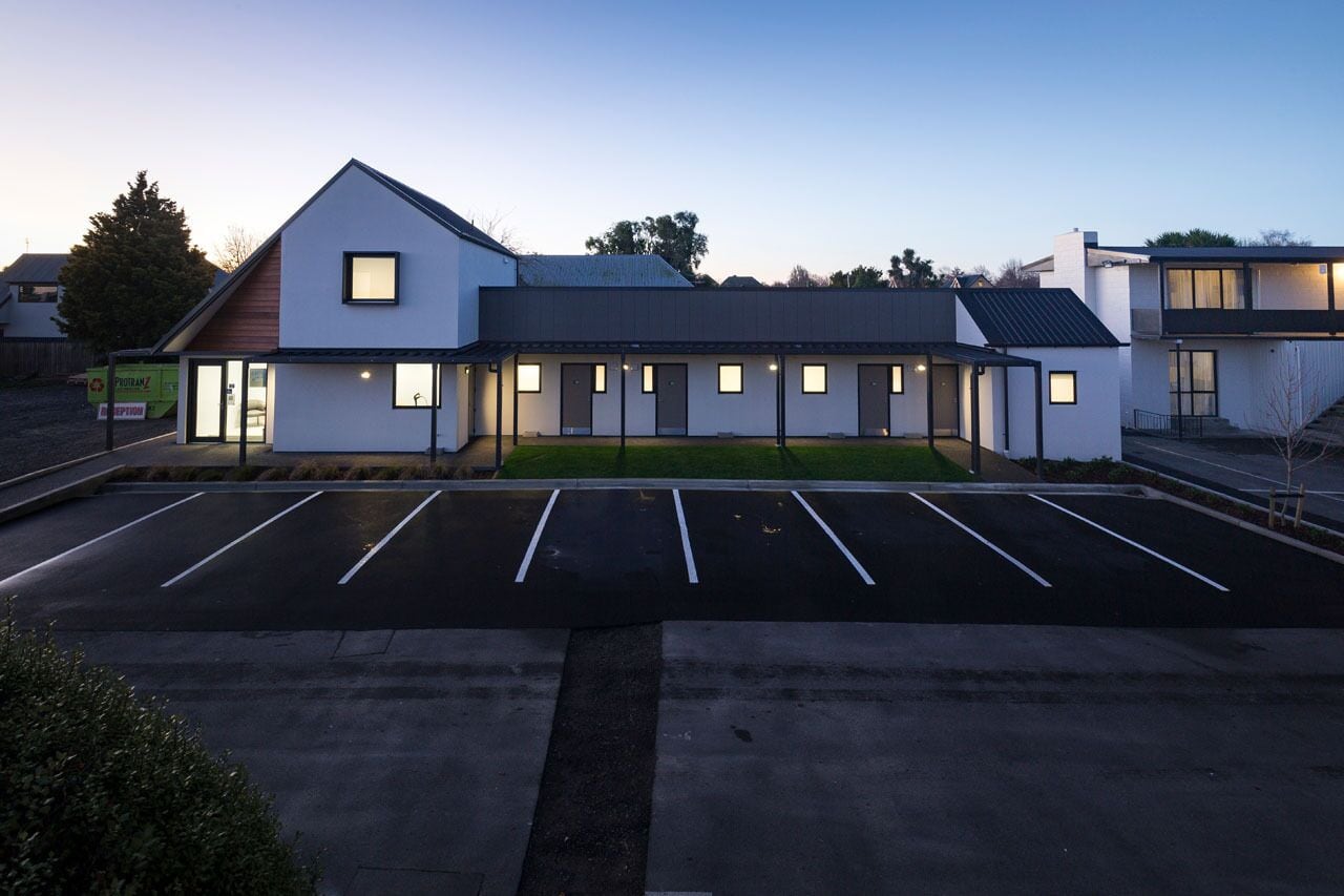 Un edificio moderno con un parcheggio di fronte.