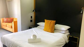 Une chambre d’hôtel équipée d’un lit, d’une table de chevet, d’une chaise et d’un climatiseur fixé au mur.