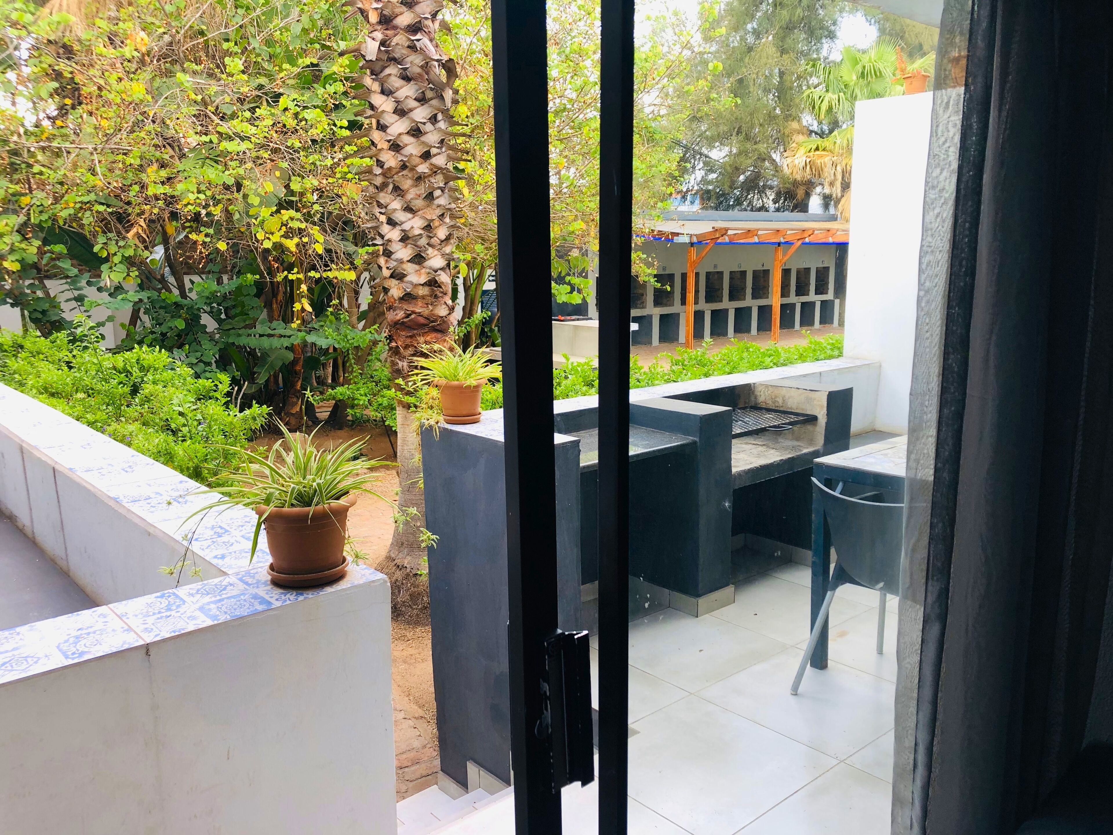 A patio area with a seating arrangement, potted plants, and a view of the surrounding greenery.