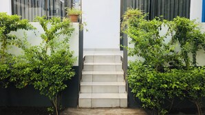 Une entrée propre et moderne, avec un escalier menant à une porte portant les numéros 18 et 19.