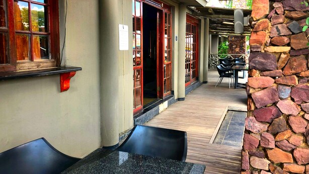 Un restaurant doté d’une terrasse, de murs en pierre et d’une enseigne.