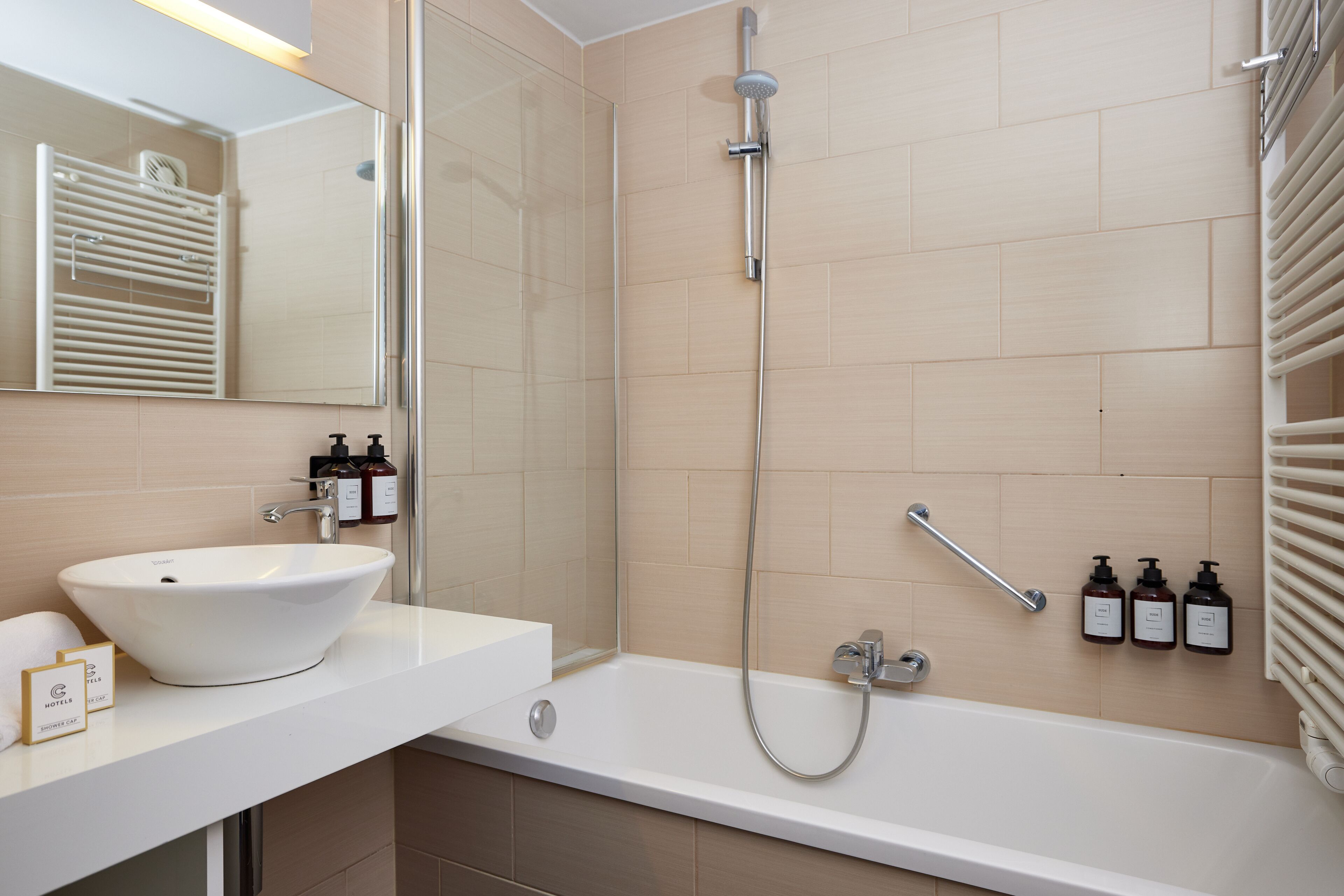 A modern bathroom with a white sink, a bathtub, a shower, and a towel rack.