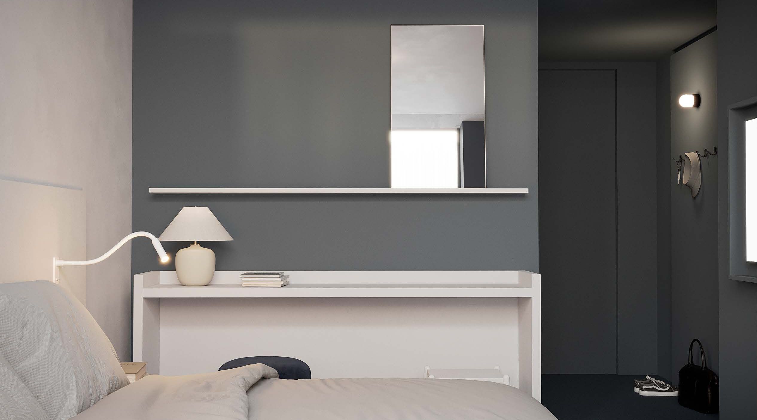 Un dormitorio moderno con cama, lámpara de noche y un espejo sobre una consola blanca.