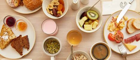 A breakfast table with various food items and drinks.