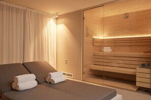 A modern hotel room with a large bed, a glass shower enclosure, and a wooden sauna area. - Hotel Burlington (Ostend)