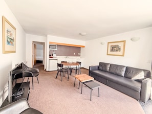 A compact living space with a kitchenette, a dining area, and a seating area. - Amity Serviced Apartments (Queenstown)
