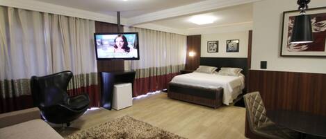 A hotel room with a bed, a TV, a desk, and a chair.