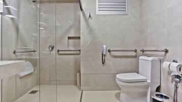 Une salle de bain moderne dotée d’une douche à parois de verre, de toilettes et d’un bidet.
